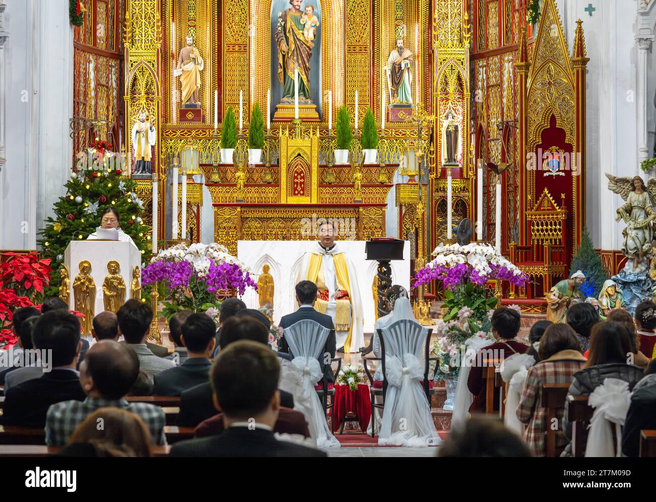 Un sacerdote cattolico vietnamita agisce come officiante e celebrante in un matrimonio nella Cattedrale di San Giuseppe ad Hanoi, in Vietnam. Foto Stock