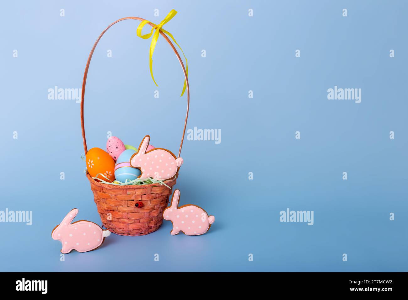 Grazioso pan di zenzero rosa a forma di coniglio e un cestino con uova di Pasqua decorative Foto Stock