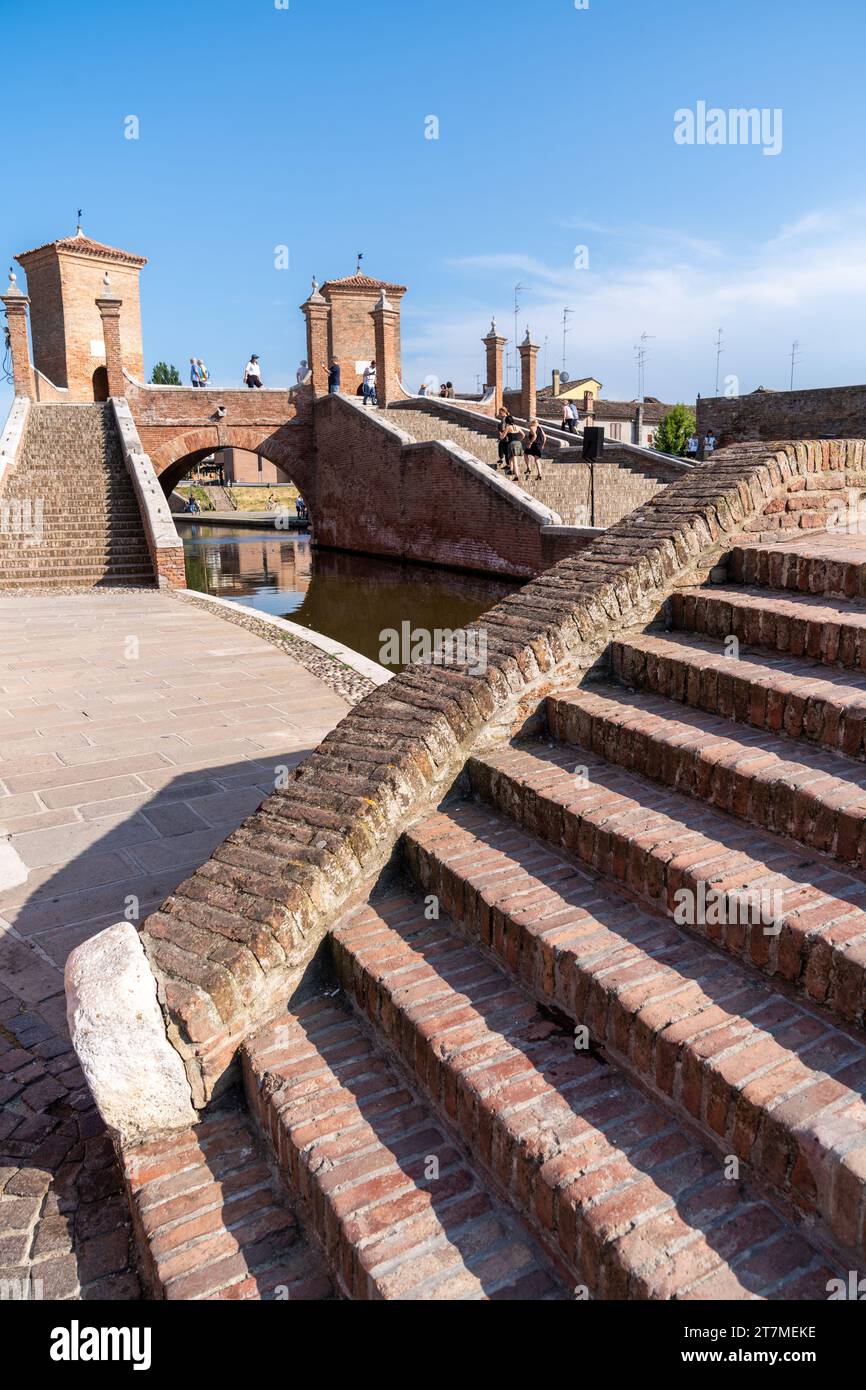 Comacchio, Italia-2 giugno 2023: Le persone passeggiano a Comacchio davanti ai famosi tre ponti durante una giornata di sole Foto Stock