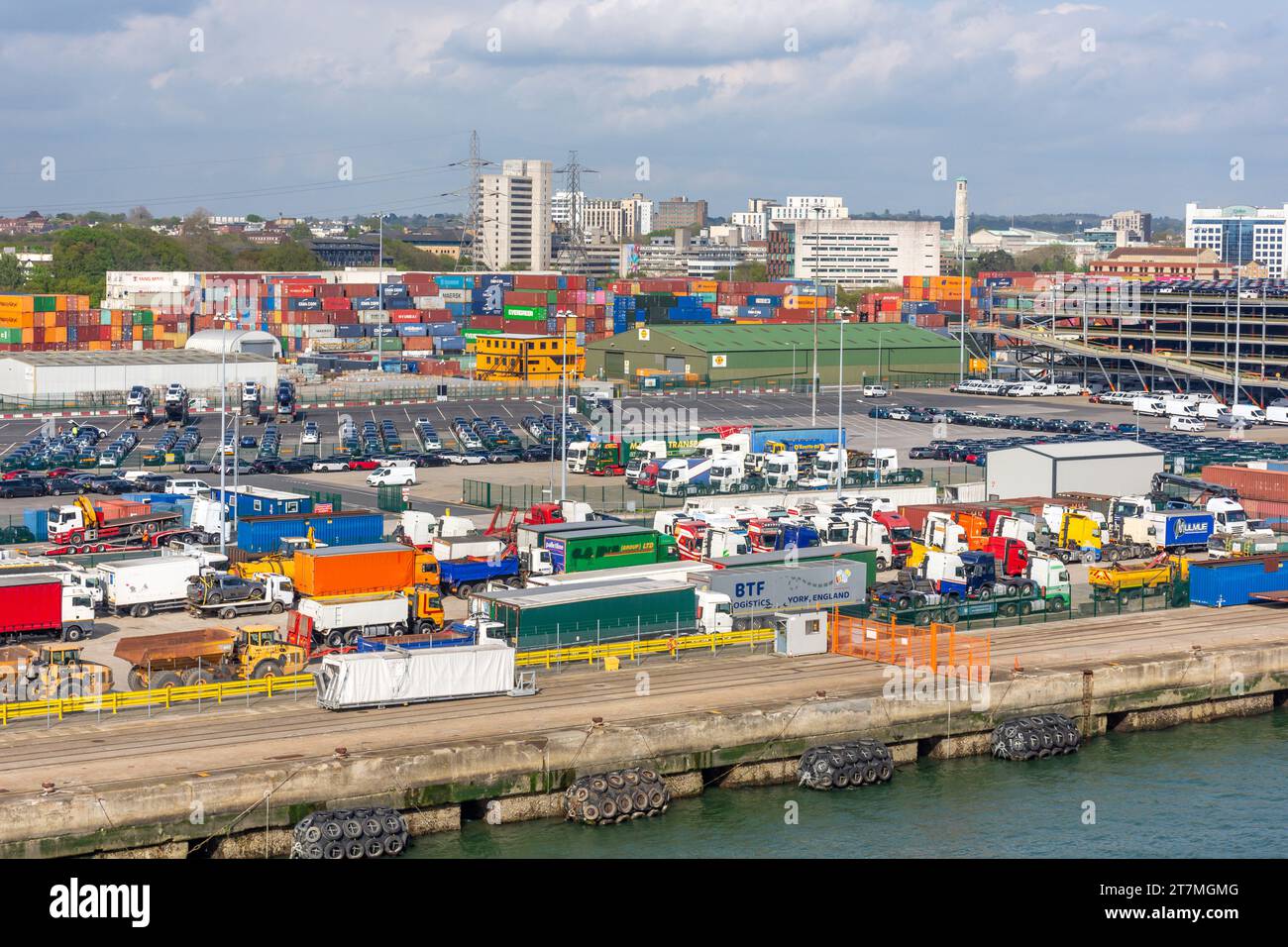 Container impilati e veicoli parcheggiati a Port of Southampton, Southampton, Hampshire, Inghilterra, Regno Unito Foto Stock