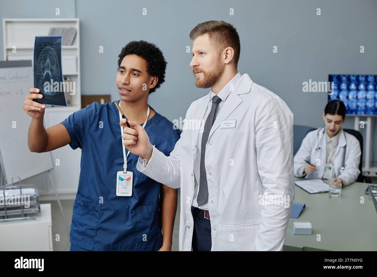 Vita su ritratto di due medici che discutono di immagine a raggi X del cervello in piedi in clinica medica, copia spazio Foto Stock
