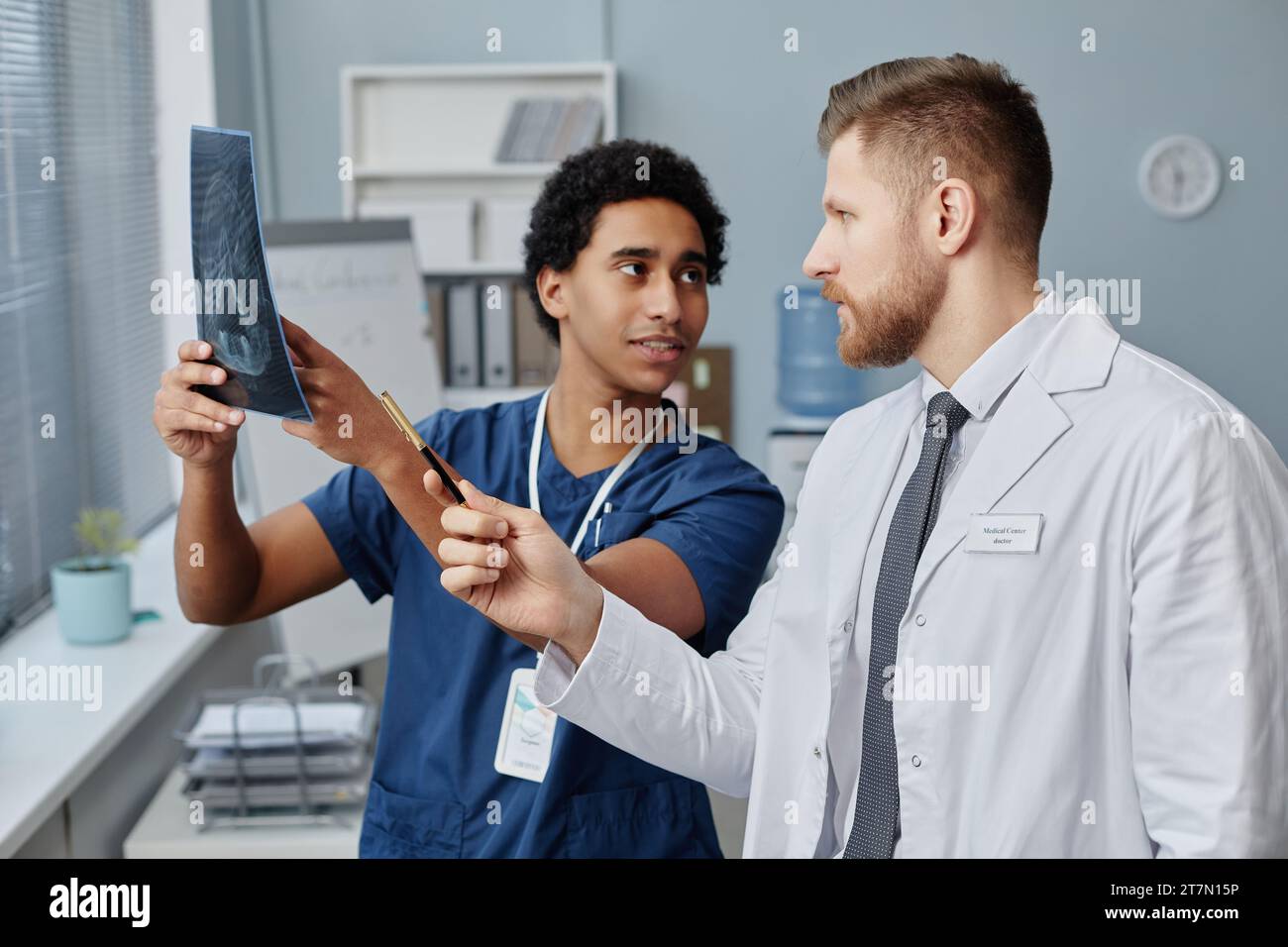 Vita ritratto di due medici che detengono l'immagine radiografica del cervello e discutono il caso del paziente in clinica medica, spazio copia Foto Stock