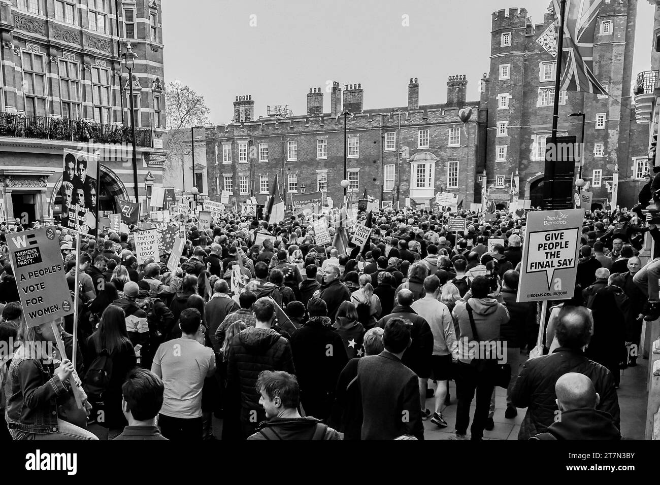 Uno scatto in bianco e nero di una grande folla di manifestanti che marciano attraverso una strada di Londra. Foto Stock