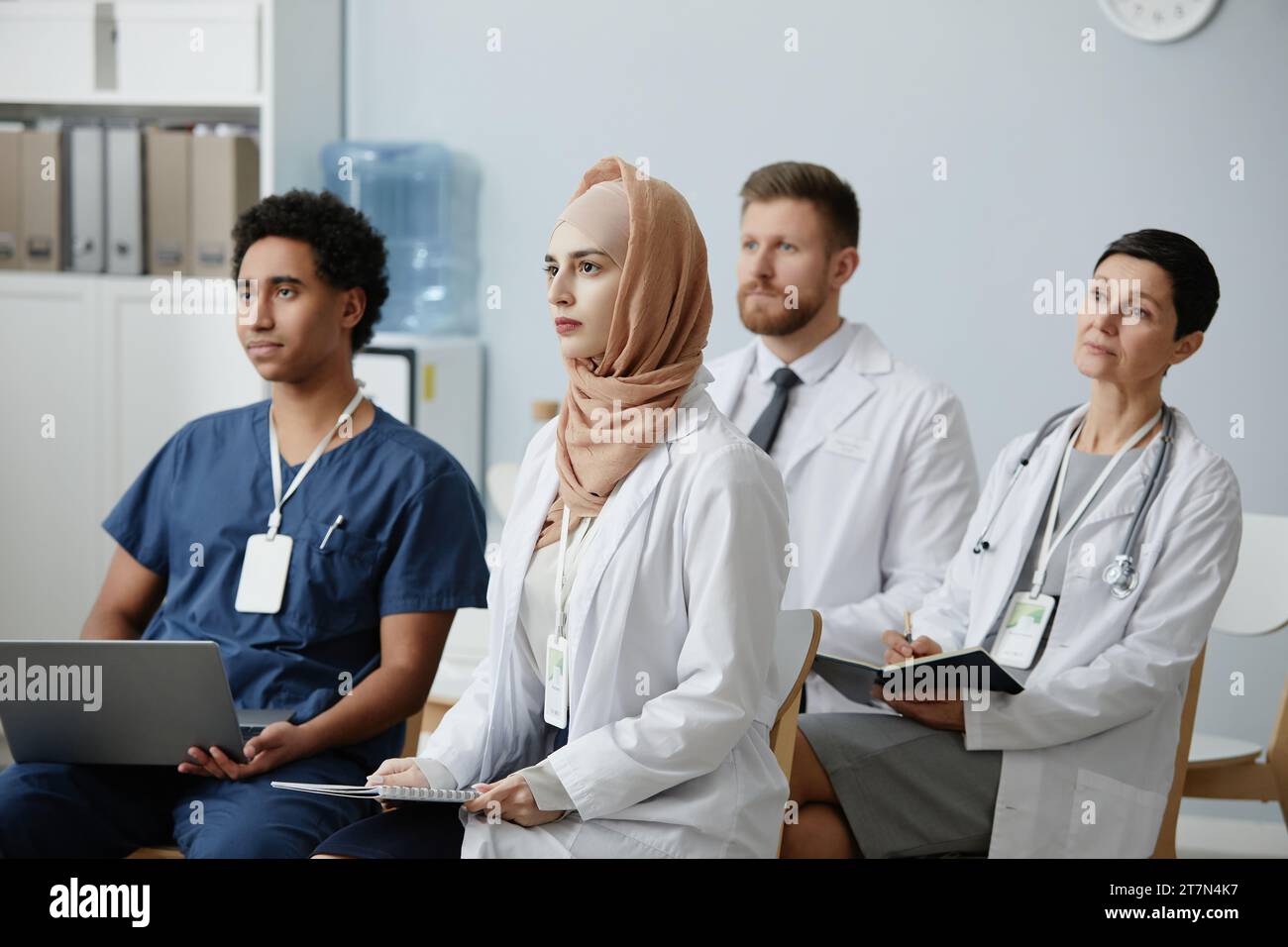 Gruppo multietnico di medici seduti in udienza a un seminario educativo e ascoltando lezioni sulla medicina Foto Stock