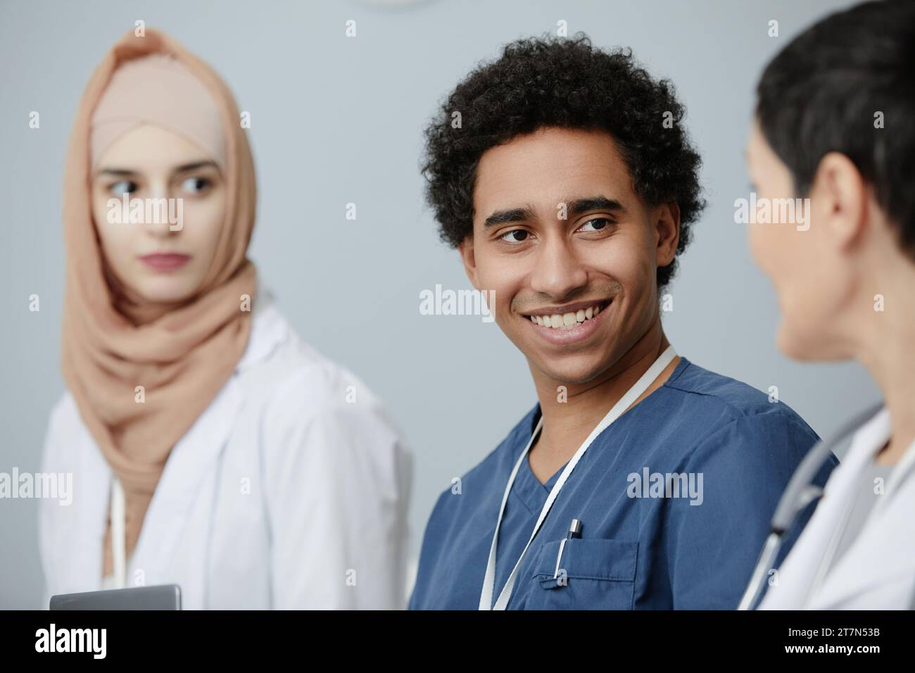 Ritratto di giovane uomo mediorientale seduto in pubblico al seminario di medicina e sorridente, spazio copia Foto Stock