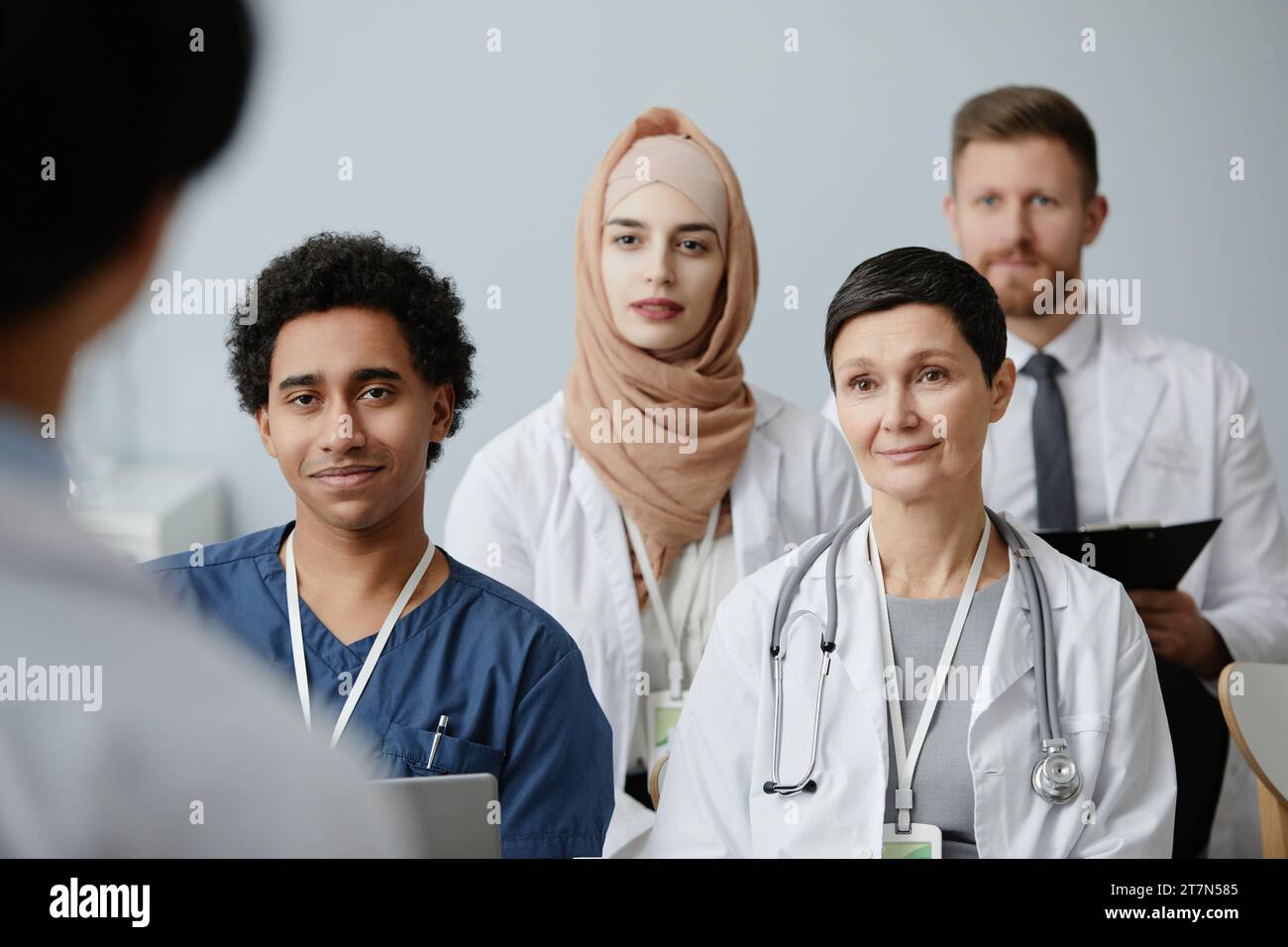 Gruppo multietnico di medici sorridenti in udienza alla conferenza ascoltando una lezione sulla medicina Foto Stock