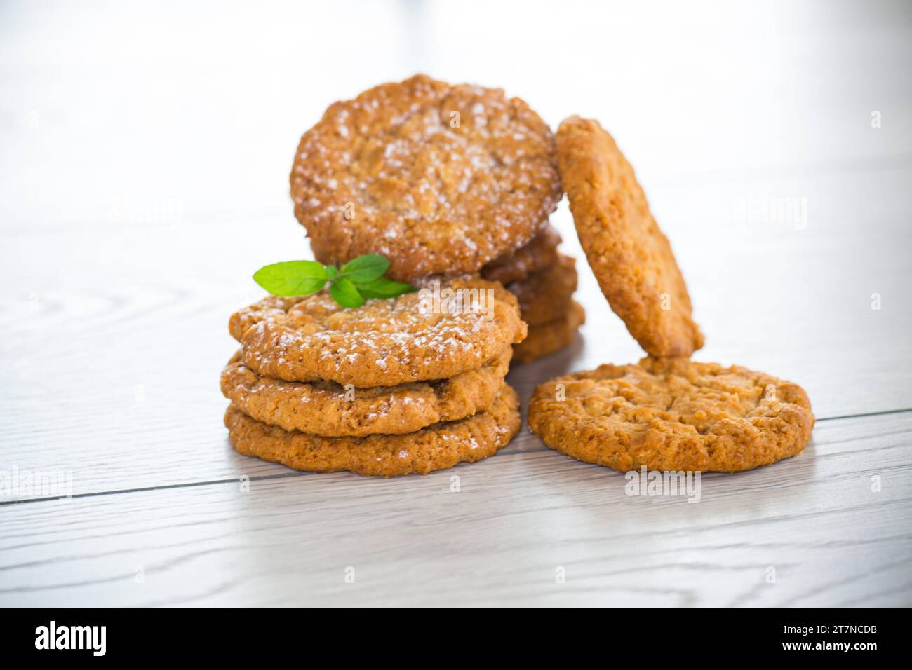 biscotti dolci cotti di farinata d'avena su un tavolo di legno chiaro Foto Stock
