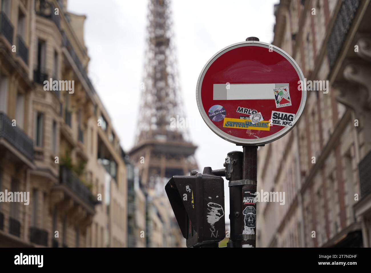 Parigi, Francia, 25.07.2023: Segnale di stop coperto da adesivi sullo sfondo della Torre Eiffel Foto Stock