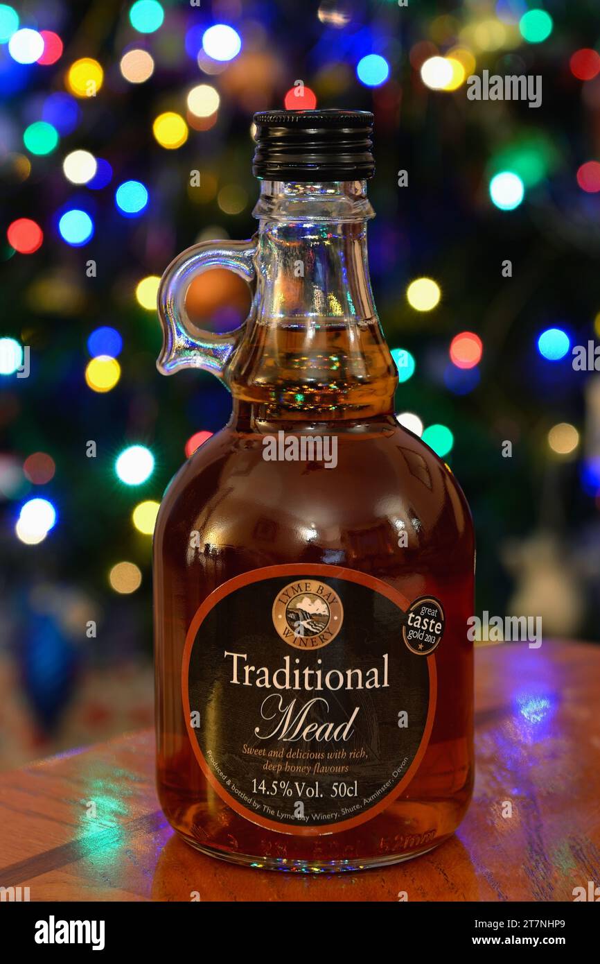 Una bottiglia di tradizionale vino idromele sul tavolo con le luci delle fate di Natale dietro. Foto Stock