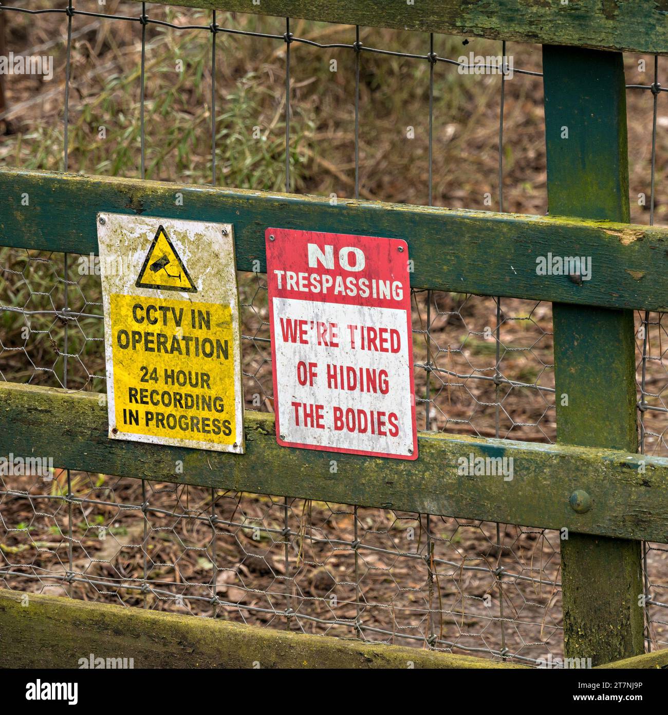 Avvertenza CCTV in funzione e segnali umoristici di assenza di Trespassing su recinzione di legno, Inghilterra, Regno Unito Foto Stock