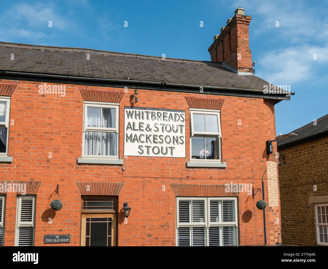 Old vintage dipinto Whitbread's Ale and Stout, Mackeson's Stout pubblicità segno su mattoni rossi casa / pub muro, Somersby, Leicestershire, Regno Unito Foto Stock
