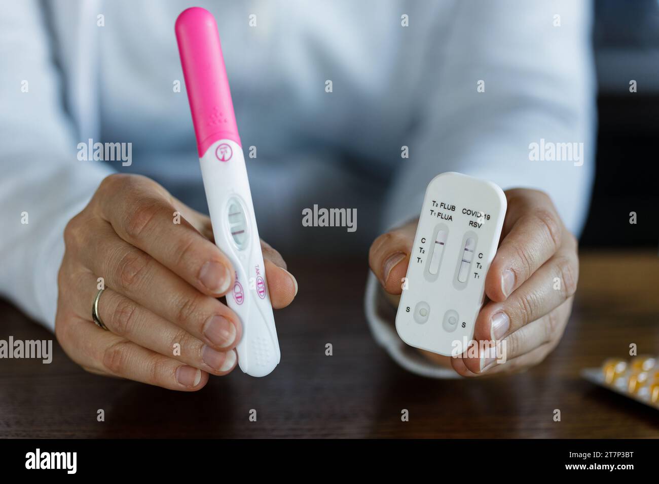 Donna che ha un test di gravidanza positivo e un test COVID positivo. Una donna incinta malata non può usare la medicina. Foto Stock