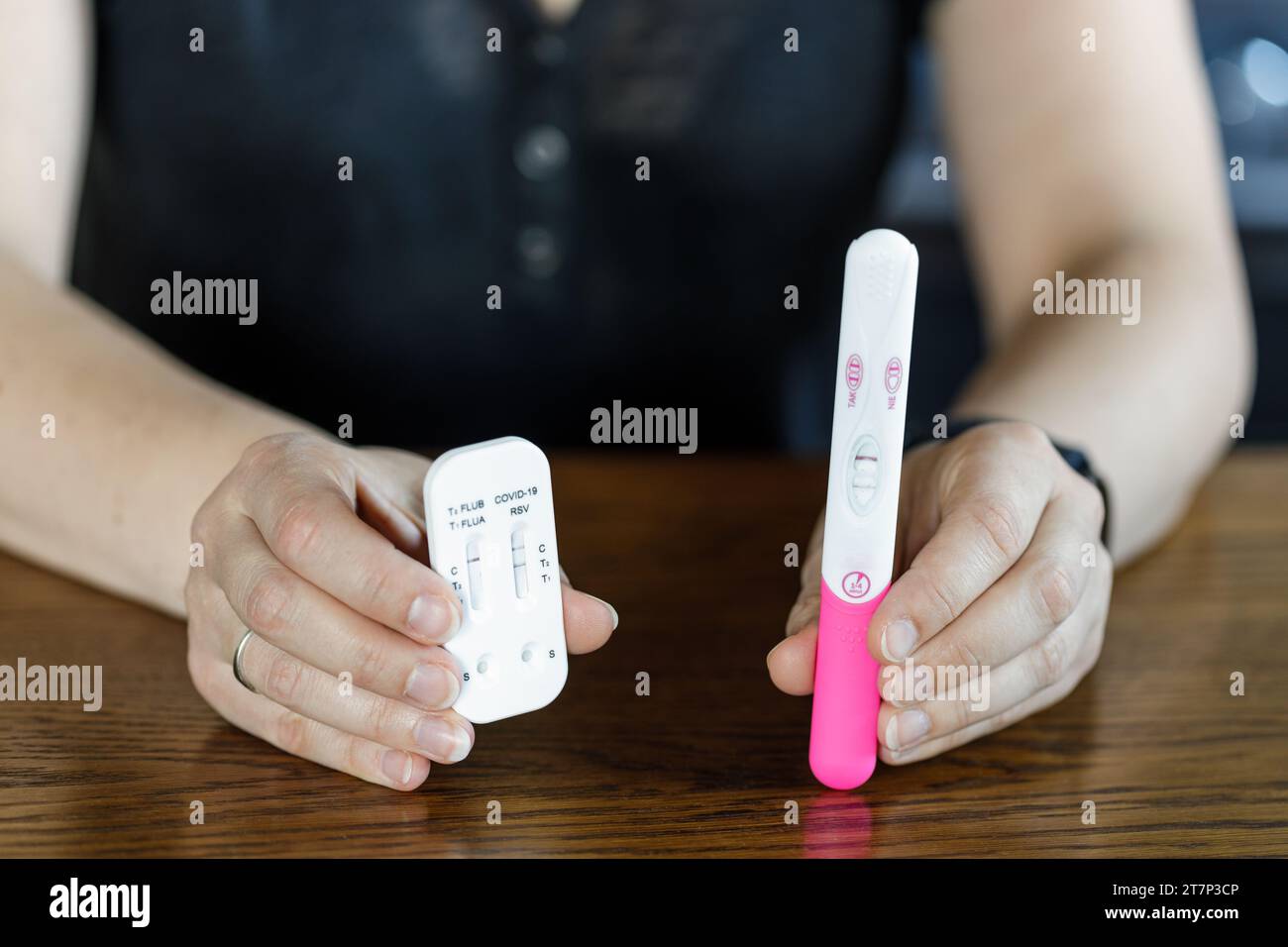 Donna che ha un test di gravidanza positivo e un test COVID positivo. Una donna incinta malata non può usare la medicina. Foto Stock