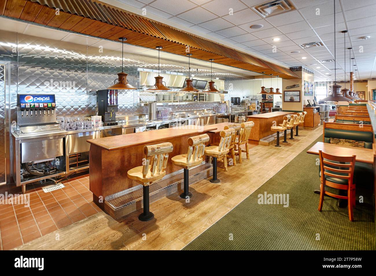 Il banco pranzo, la stazione delle cameriere e l'area pranzo di un ristorante a marchio Black Bear che presenta un decor rustico e sgabelli da bar in legno. Foto Stock