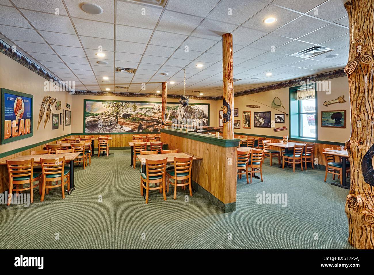 L'area pranzo di un ristorante con marchio Black Bear che mostra decorazioni rustiche e opere d'arte. Foto Stock