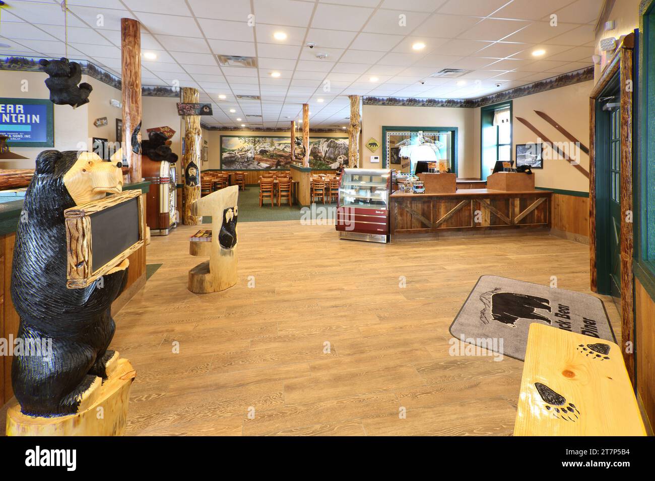 L'entrata, la stazione delle hostess, il banco dei pagamenti e l'area pranzo di un ristorante a marchio Black Bear che mostra un decor rustico e opere d'arte. Foto Stock
