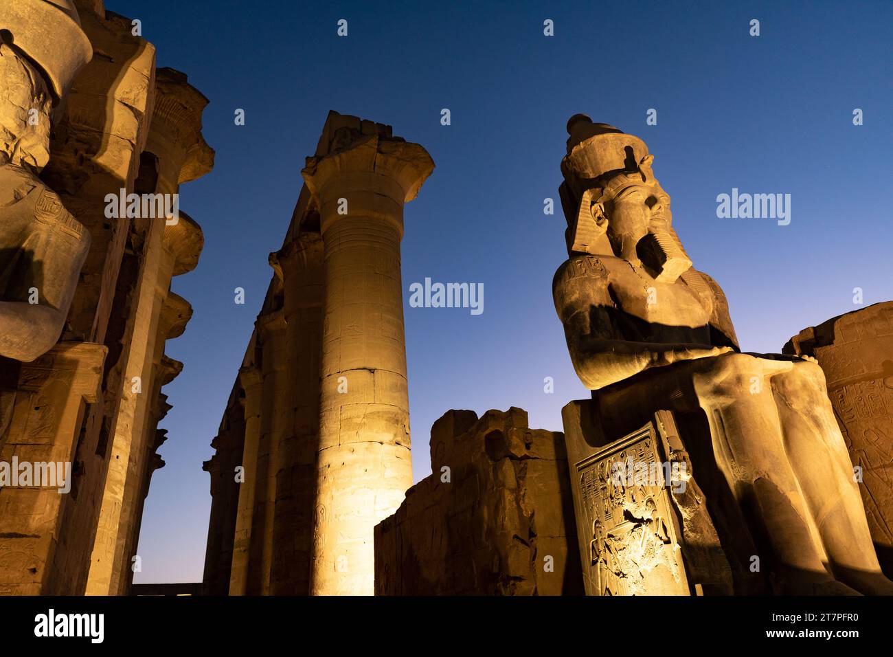 Vista notturna delle statue, delle colonne e dei geroglifici del tesoro archeologico e della destinazione turistica del tempio di Luxor illuminata di notte Foto Stock