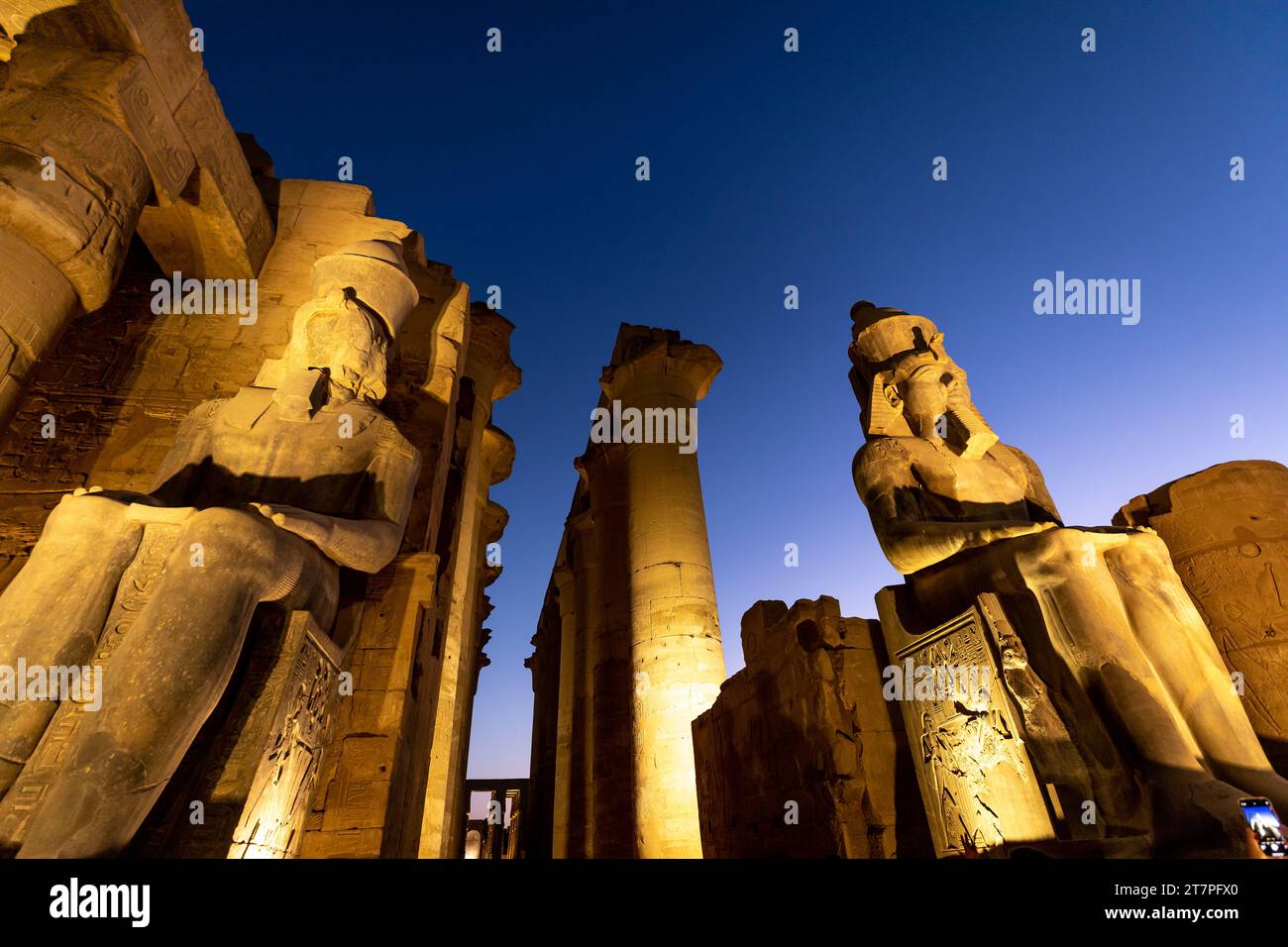 Vista notturna delle statue, delle colonne e dei geroglifici del tesoro archeologico e della destinazione turistica del tempio di Luxor illuminata di notte Foto Stock