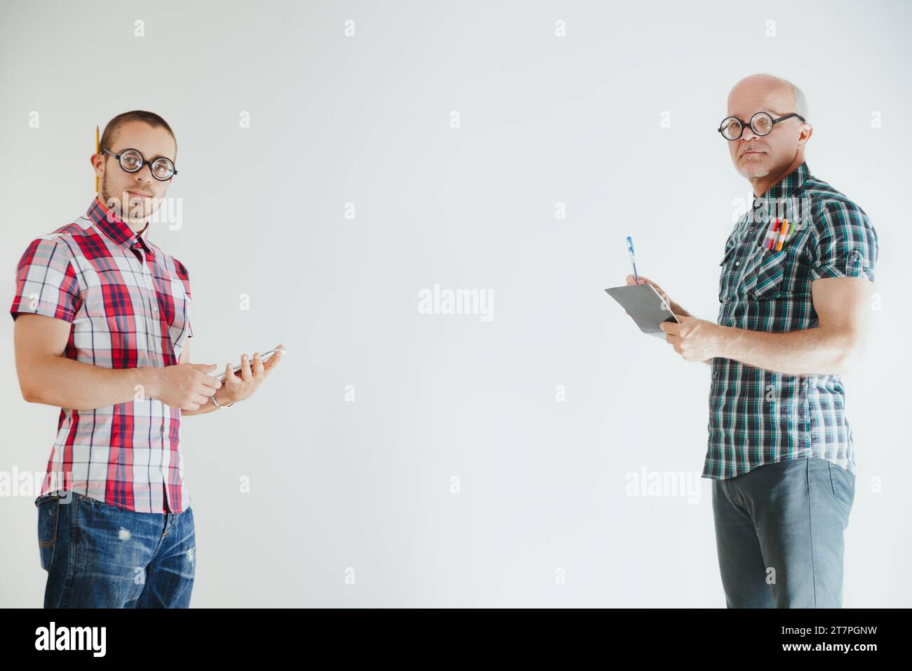 La coppia di professionisti brainiac nerdy utilizza la tecnologia e gli strumenti di scrittura per la produttività Foto Stock