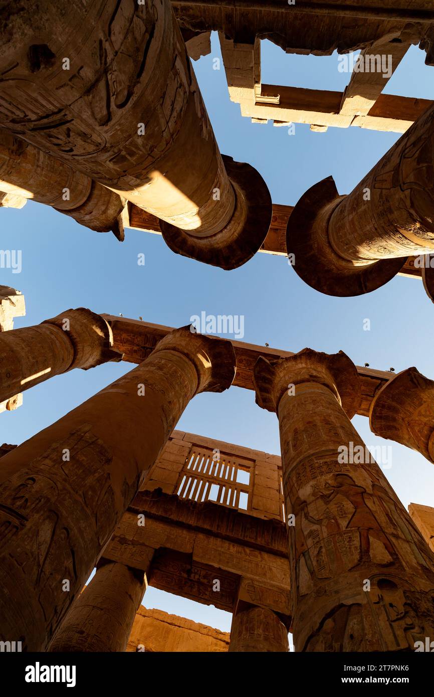 Gigantesche colonne di pietra incise con geroglifici all'interno dell'antico tempio egizio di Karnak Foto Stock