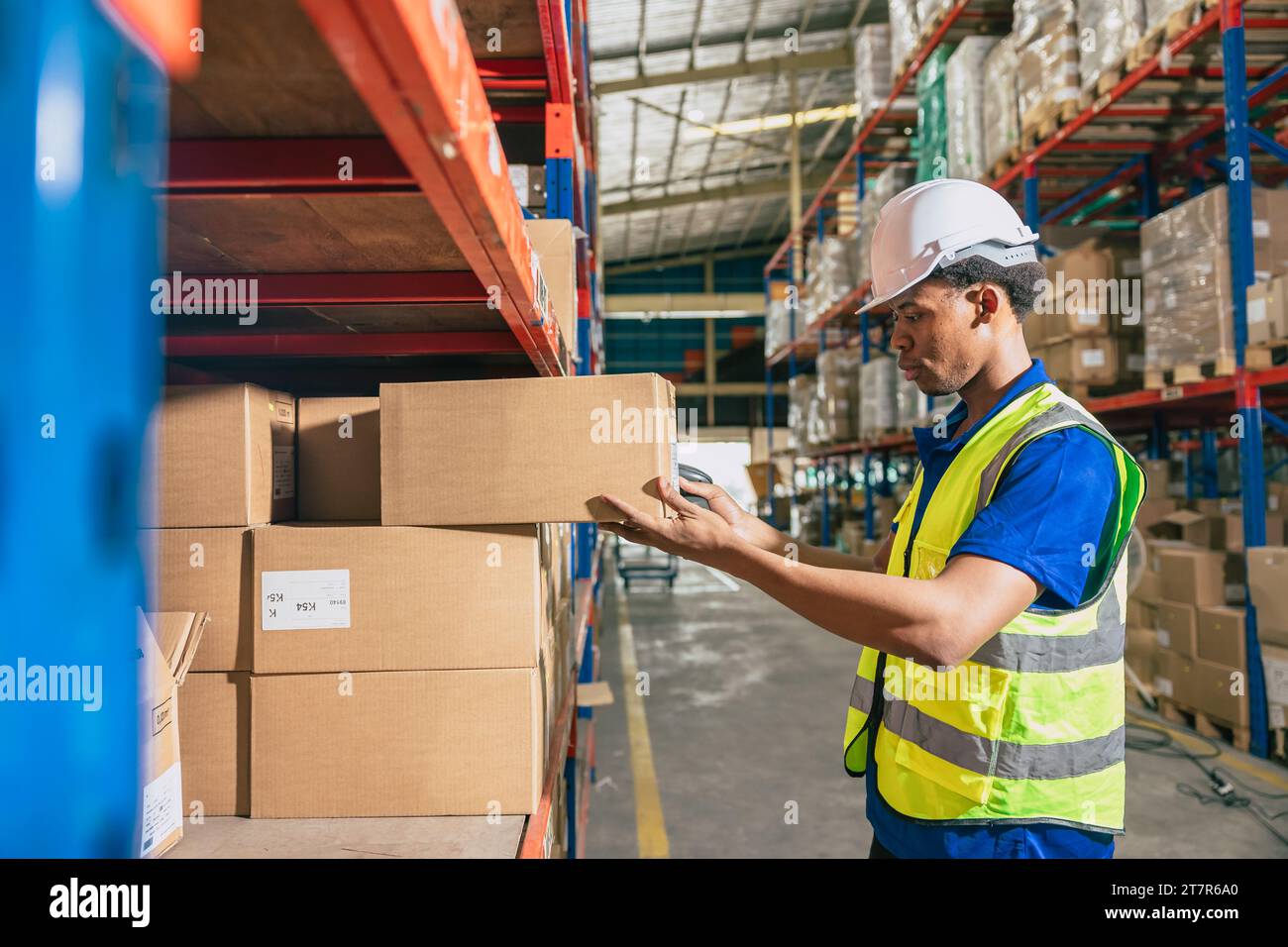 operaio nero africano di magazzino. il personale addetto all'inventario lavora nello scaffale di stoccaggio del carico controlla i prodotti rimanenti ordinati per la spedizione. Foto Stock