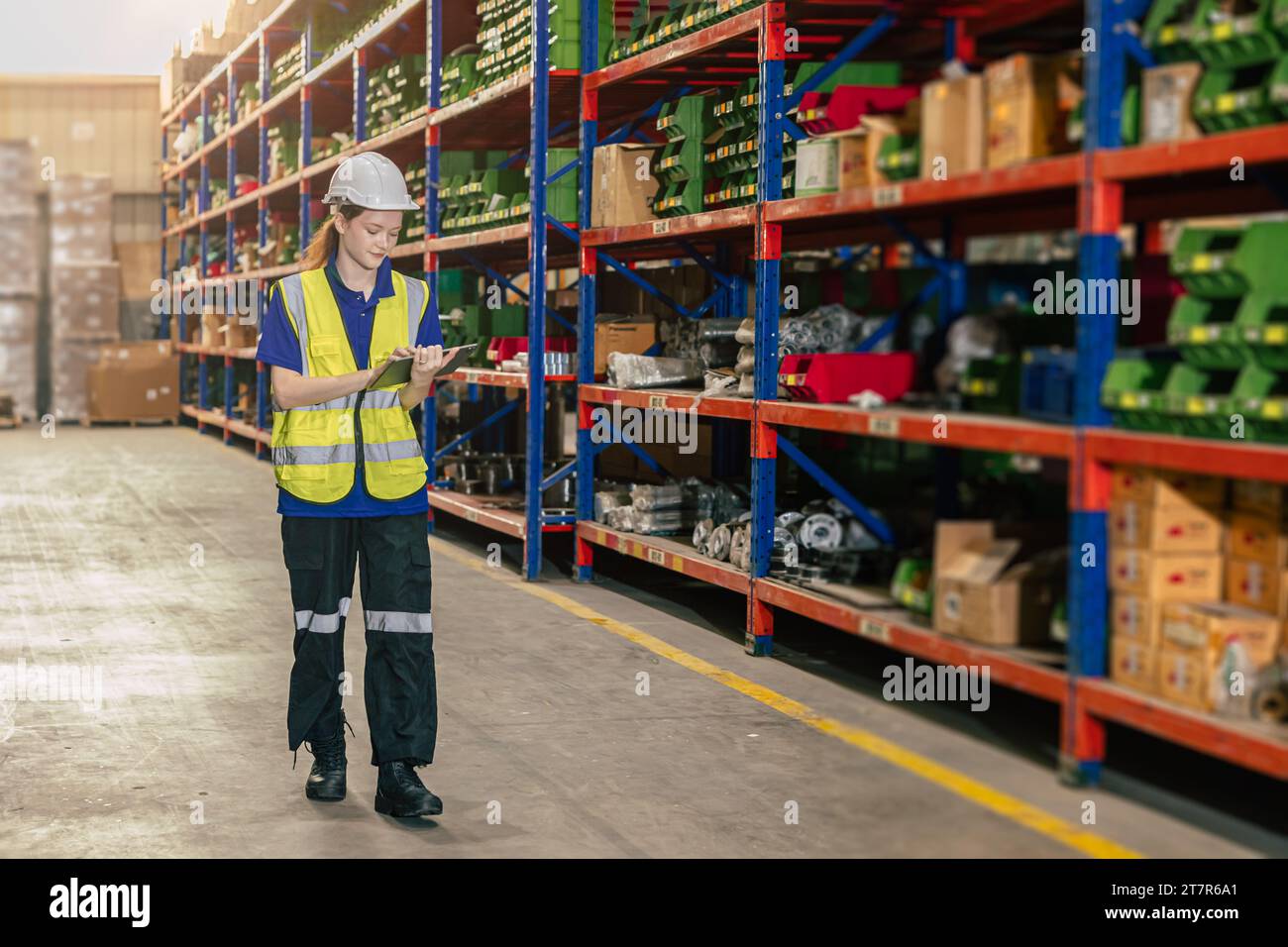 addetto al magazzino. il personale addetto all'inventario lavora in magazzino nella scaffalatura di stoccaggio del carico gestisce il controllo dell'ordine di spedizione tramite tablet. Foto Stock