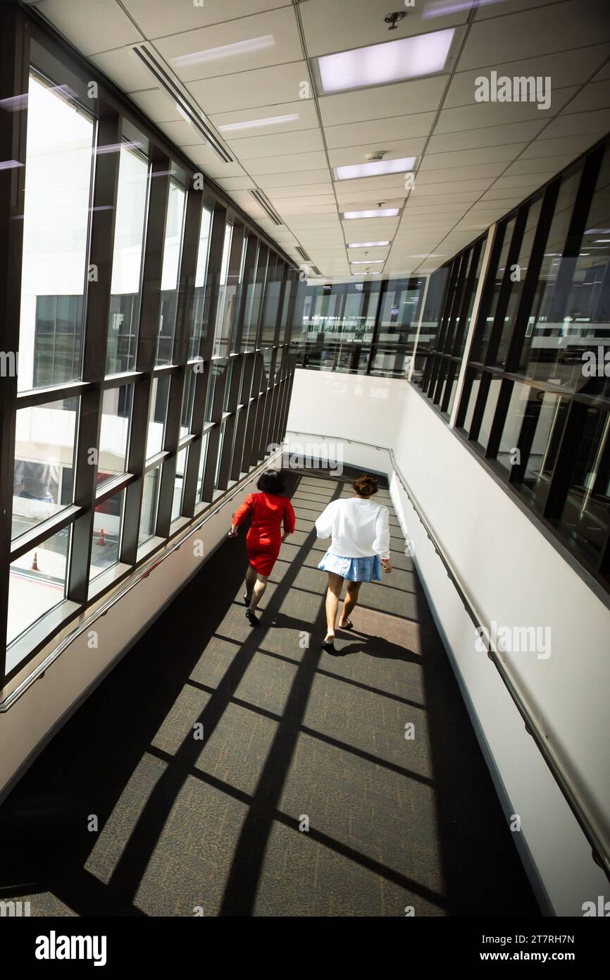 Una donna non identificata con equipaggio ha raggiunto il cancello d'imbarco dopo un'ultima chiamata a bordo presso un terminal aeroportuale in vacanza. Foto Stock