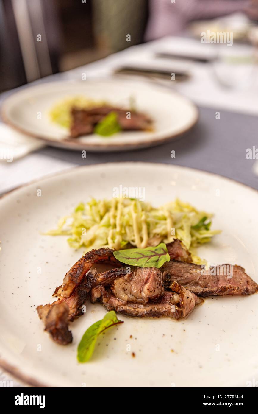 Fette di manzo con entrecote Wagyu e lattuga fresca su un piatto bianco Foto Stock