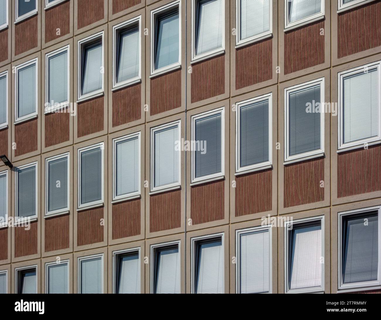 Foto full frame che mostra la facciata di un edificio di uffici con finestre con persiane chiuse Foto Stock