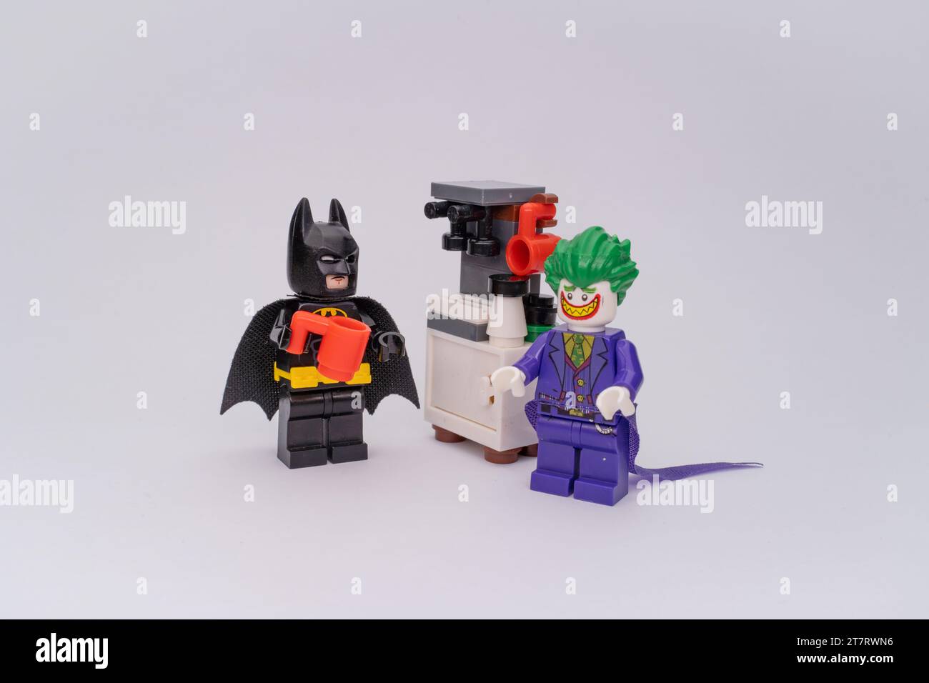 Le figure Lego di Batman e Joker in piedi accanto a una macchina da caffè fatta di pezzi Lego. Foto Stock