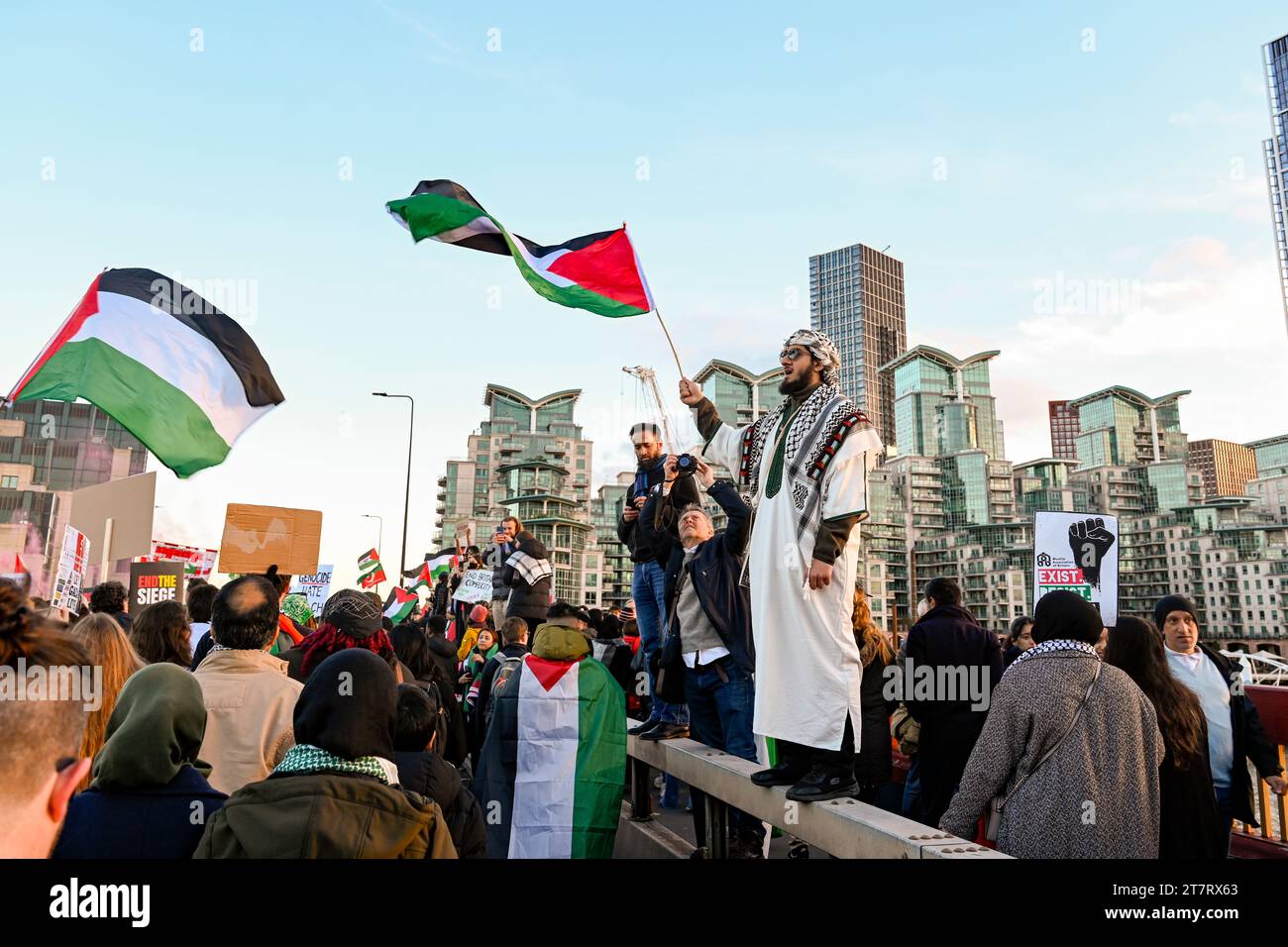 Uomo che indossa keffiyeh che sventola bandiera palestinese in marcia per la Palestina a Londra l'11 novembre 2023 Foto Stock