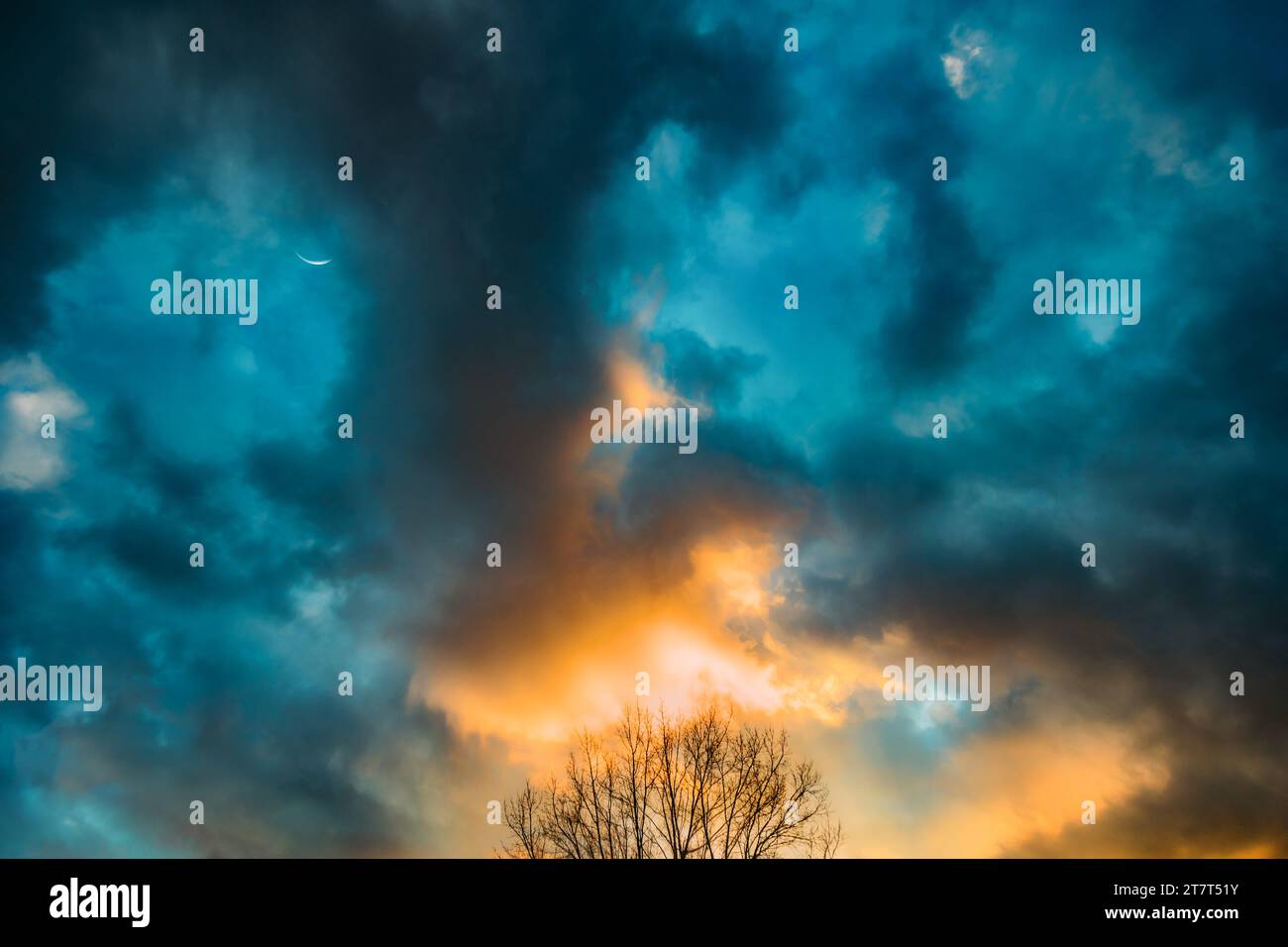 Cielo al tramonto con luna e nuvole scure Foto Stock