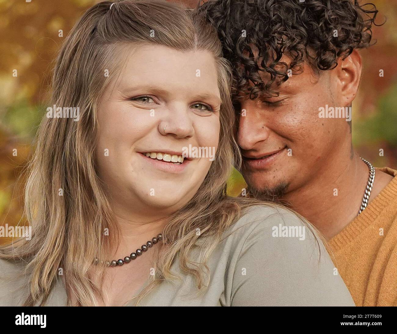 Primo piano di una donna che guarda la macchina fotografica, uomo che sbatte di lato Foto Stock