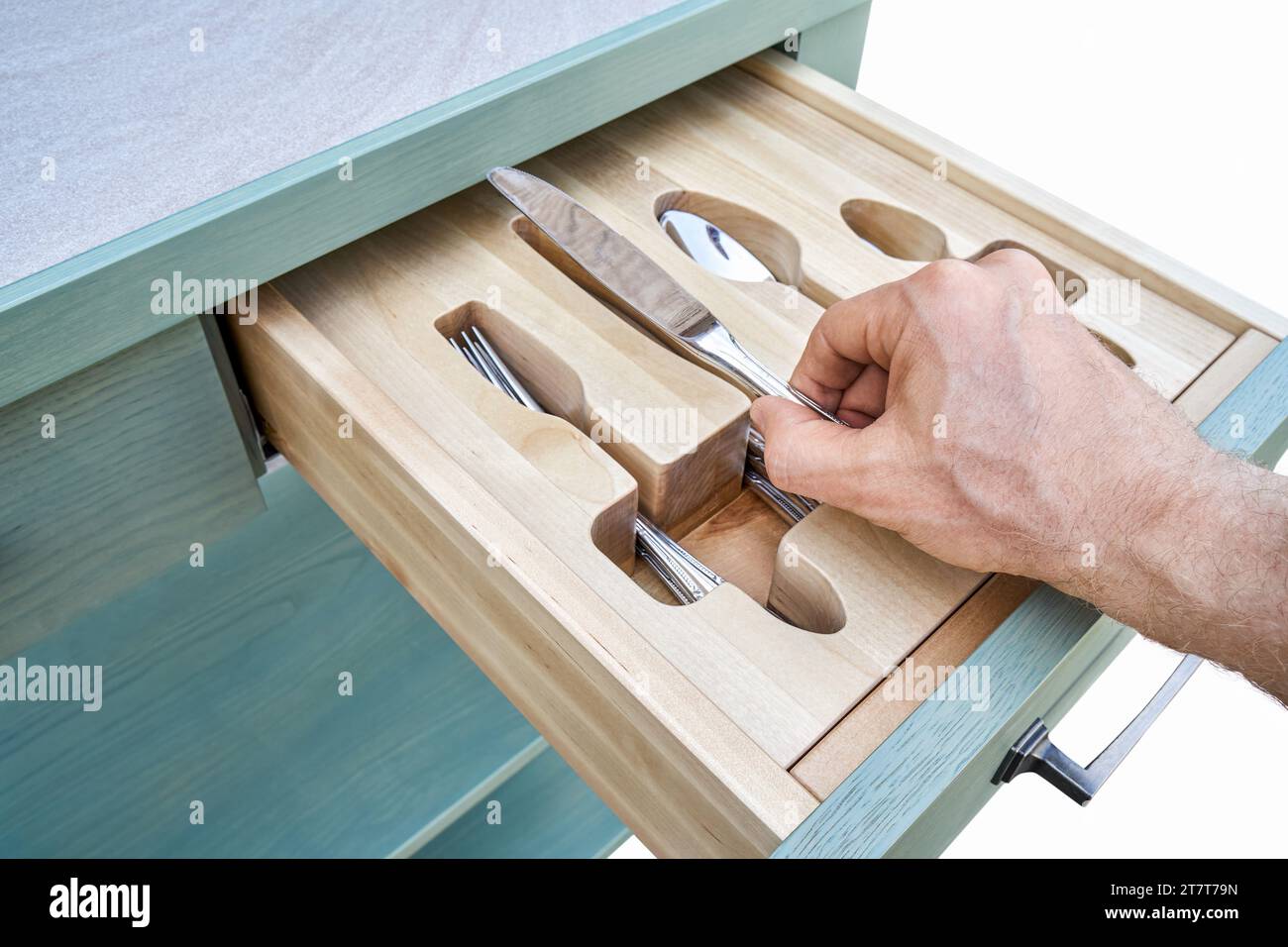 Man Hand mette il coltello in un supporto in legno affettato in un primo piano del cassetto dell'armadio da cucina. La persona prende le posate dal vassoio Mobili per la casa Foto Stock