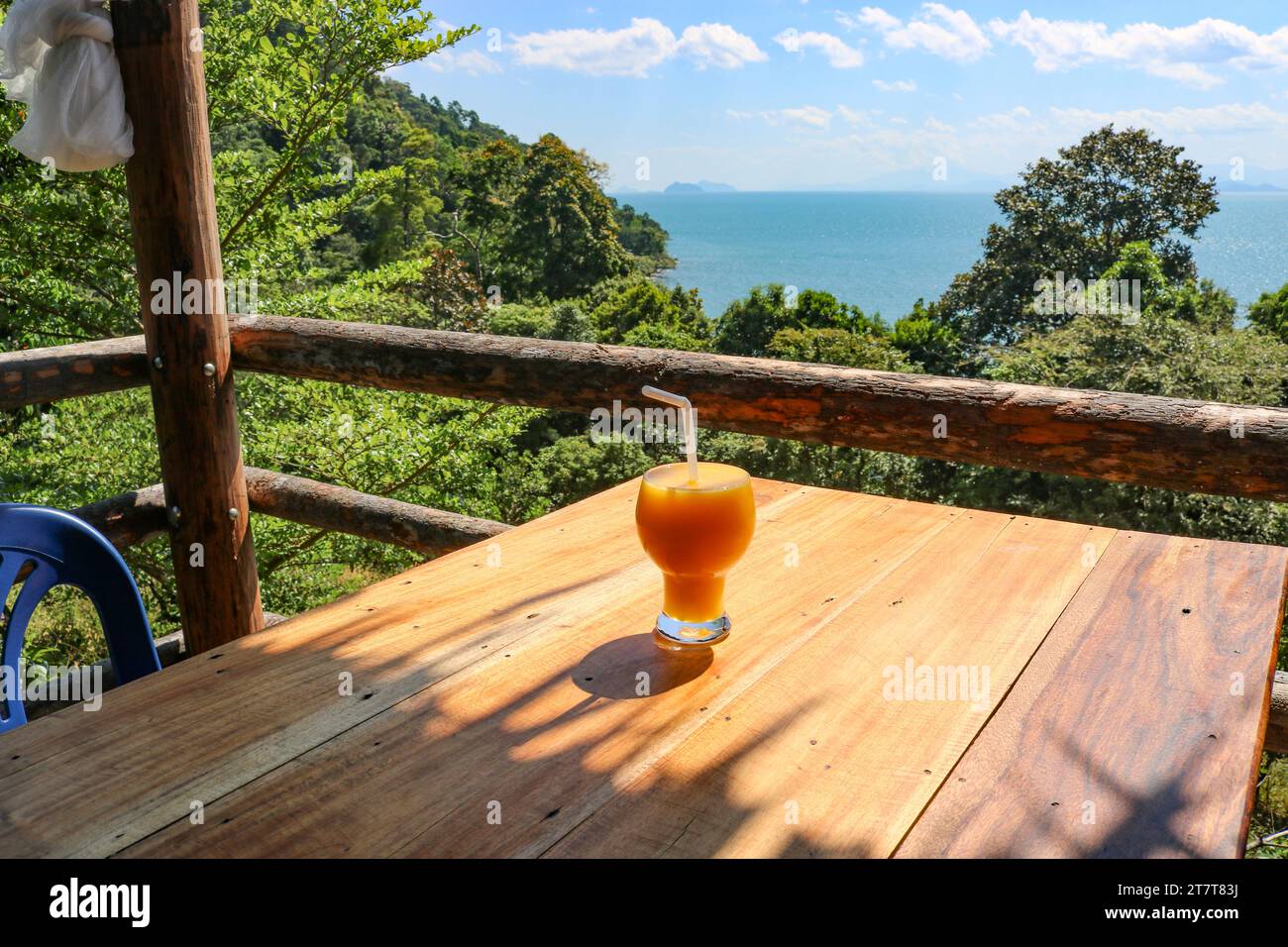 Frullato di mango in una caffetteria affacciata sul mare. Il concetto di relax, vacanza, stile di vita sano, viaggio. Foto Stock