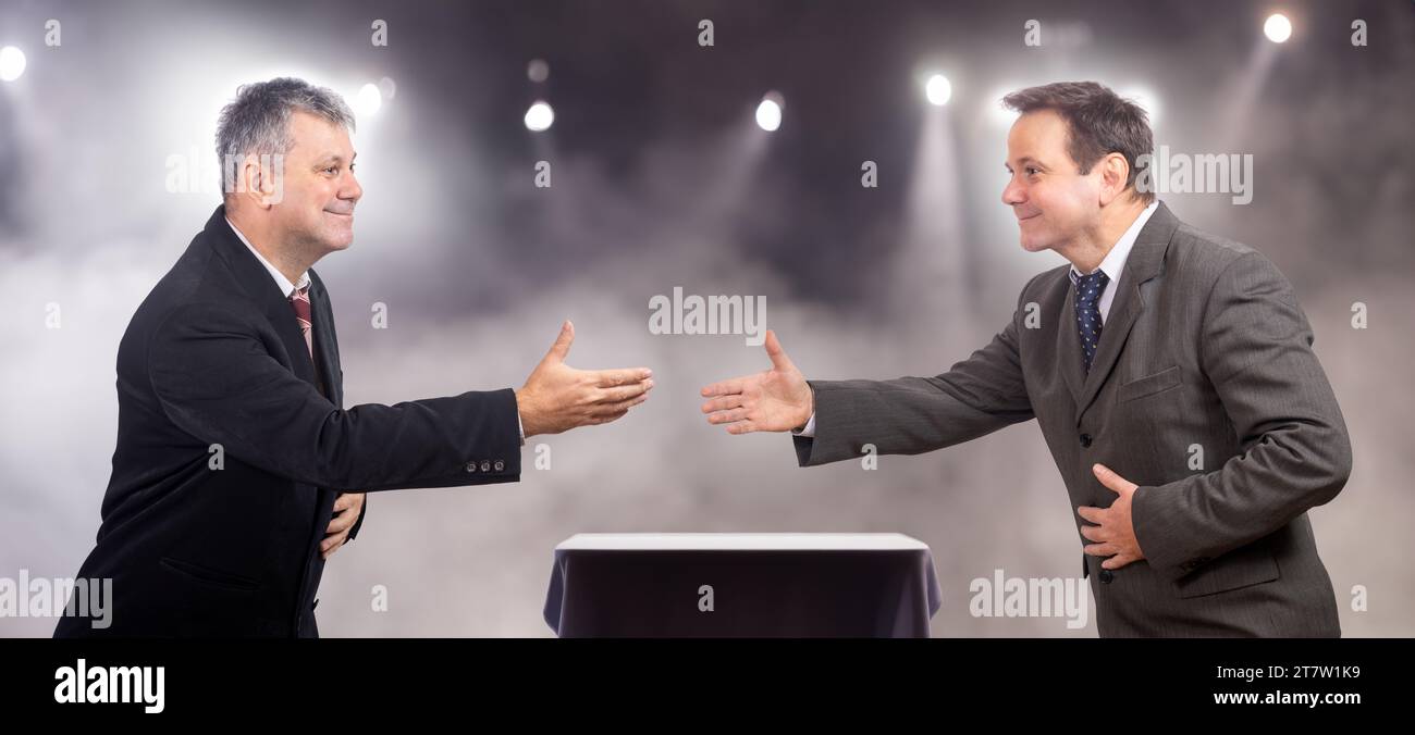 Uomini in tuta che stringono la mano sul palco Foto Stock