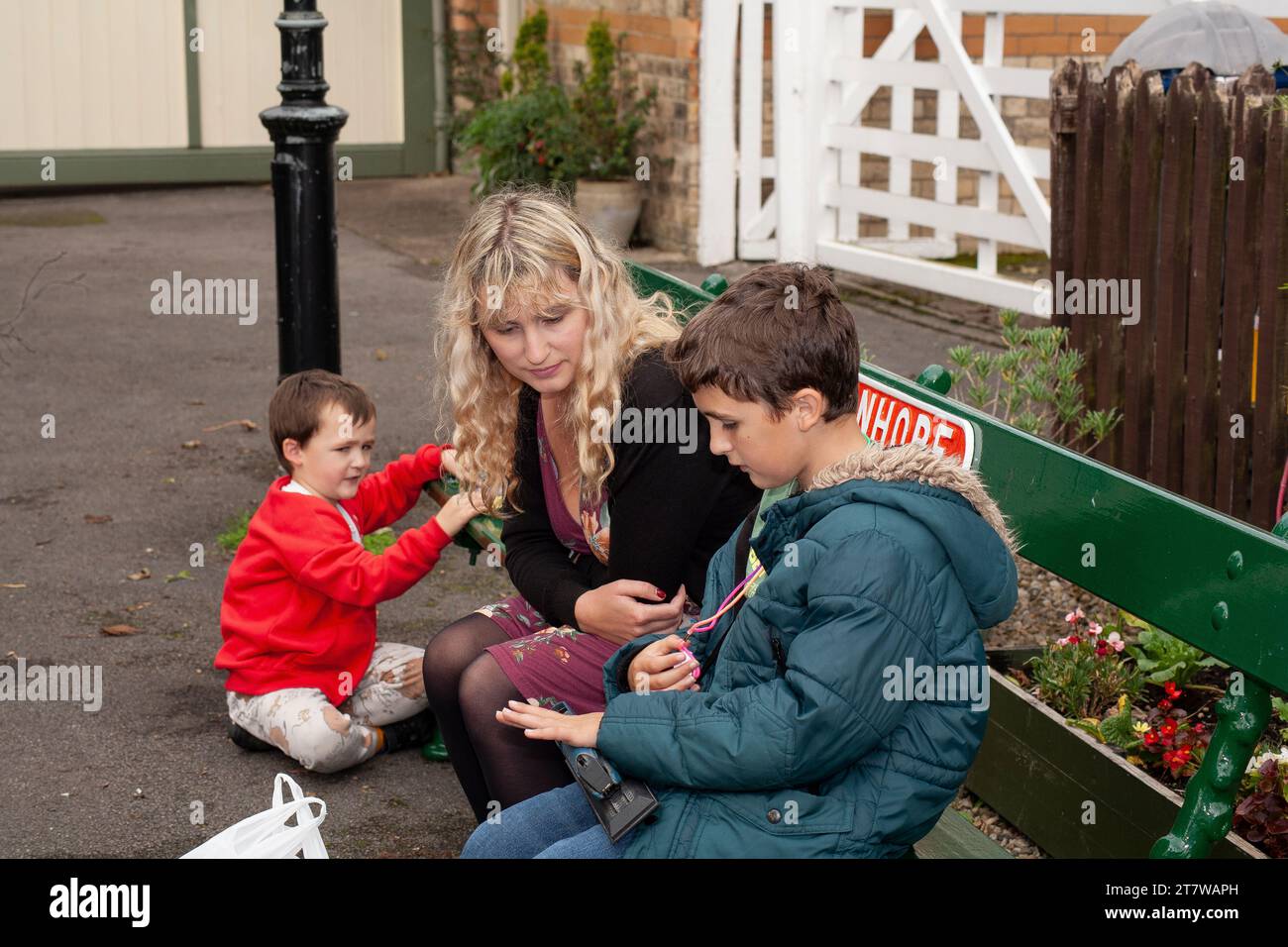 Family Bonding presso l'Heritage Station: Una scenografia pittoresca in una tradizionale stazione storica inglese in cui una giovane madre si impegna con i bambini Foto Stock