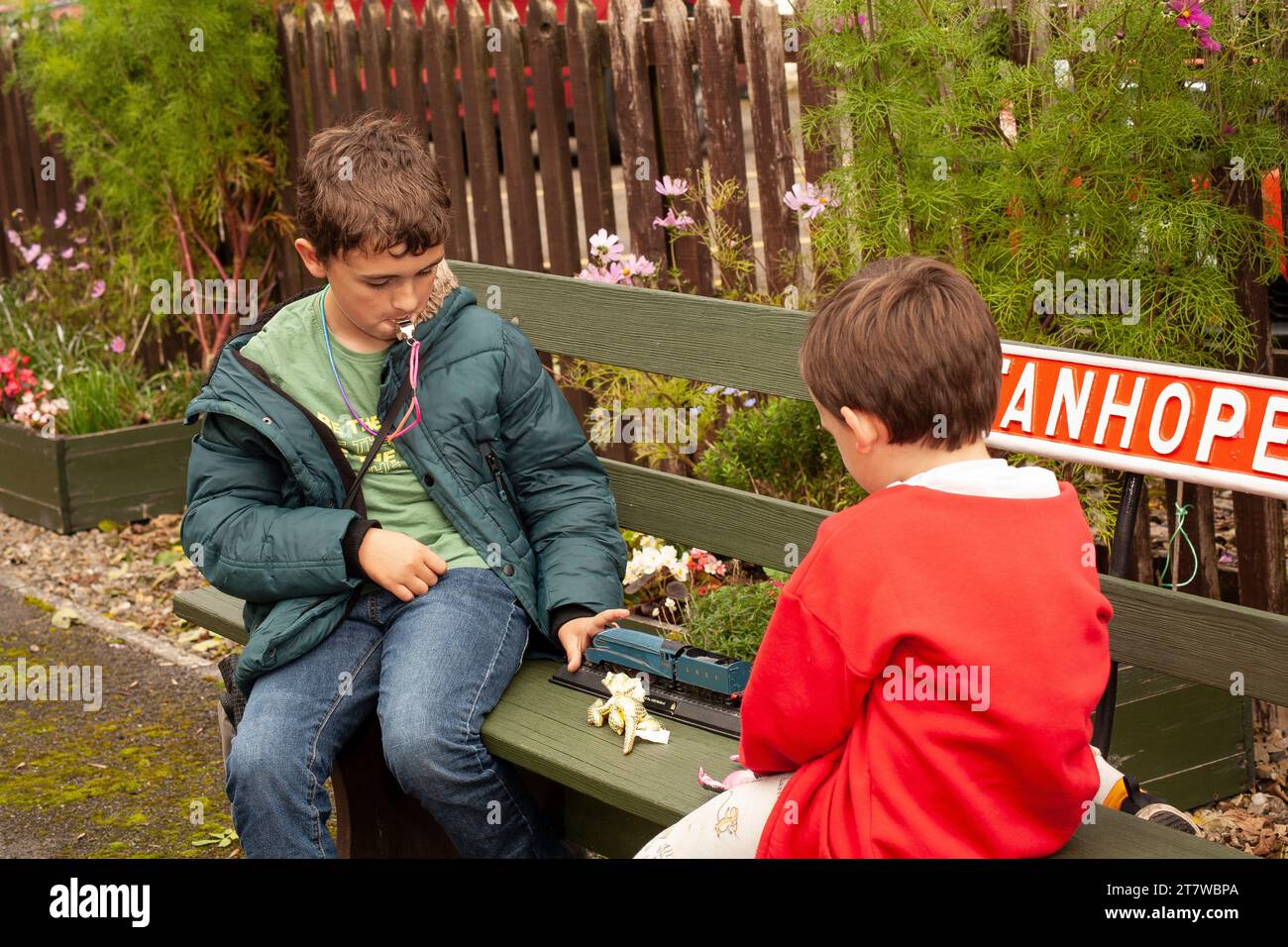 Anticipazione della Heritage Railway: Due giovani fratelli di 6 e 12 anni attendono con ansia il loro treno a Stanhope, contea di Durham. Impegnato nel gioco Foto Stock