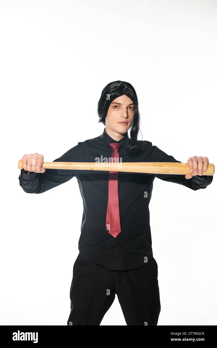 sottocultura cosplay, studente in abiti neri con parrucca e cravatta rossa che tiene la mazza da baseball su bianco Foto Stock