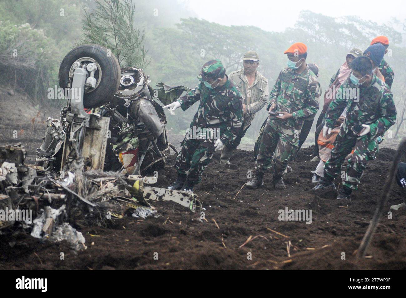 Pasuruan, Indonesia. 17 novembre 2023. Le persone ispezionano il sito dei rottami di uno dei due turboelica Super Tucano dopo che sono stati trovati schiantati a Pasuruan, Giava Est, Indonesia, il 17 novembre 2023. Due aerei da attacco leggero si sono schiantati nella provincia di Giava Orientale in Indonesia giovedì, uccidendo tutte e quattro le persone a bordo, secondo l'aviazione indonesiana. Crediti: Sahlan Kurniawan/Xinhua/Alamy Live News Foto Stock