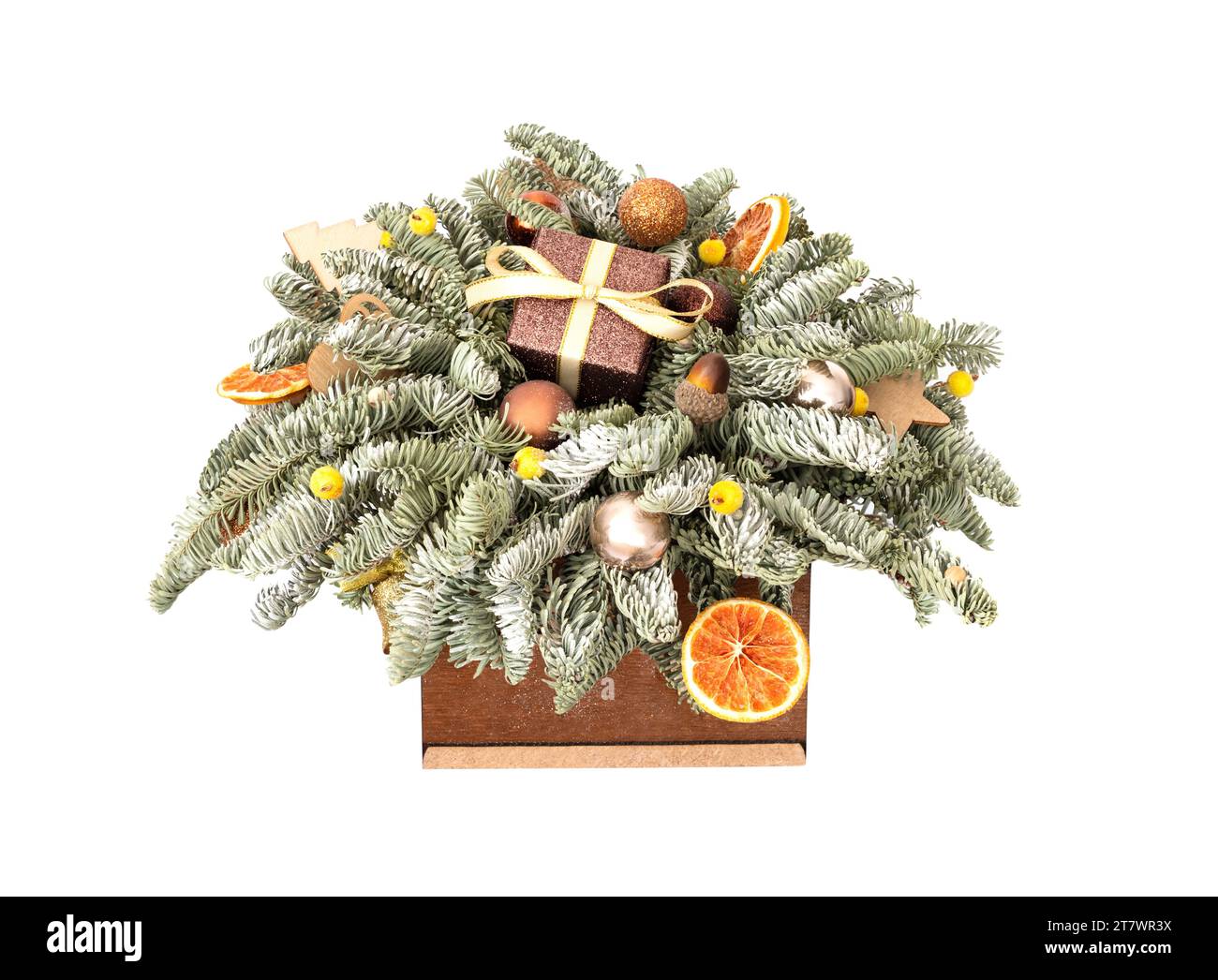 Bouquet natalizio con rami di abete, regali e decorazioni natalizie in una scatola di legno isolata su sfondo bianco. Bella composizione per il nuovo anno. Foto Stock