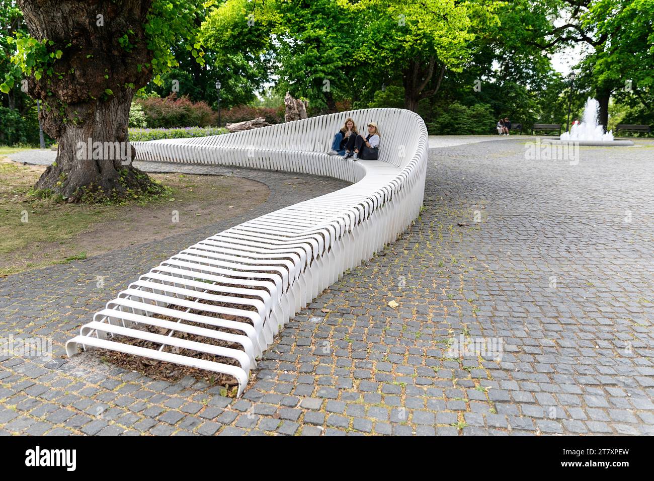 La gente del posto si rilassa su un'interessante panchina bianca moderna in uno dei parchi del centro di Tallinn, in Estonia Foto Stock