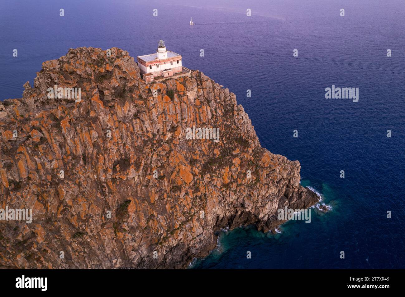 Scogliera di basalto Punta della Guardia con il faro al tramonto, isola di Ponza, mar Tirreno, isole Pontine, provincia di Latina, Lazio (Lazio), Italia Foto Stock