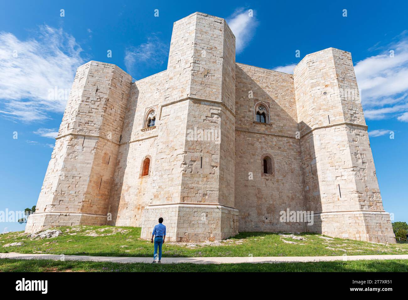 L'uomo ammira il castello ottagonale di Castel del Monte in una chiara giornata di sole, patrimonio dell'umanità dell'UNESCO, Puglia, Italia meridionale, Europa Foto Stock