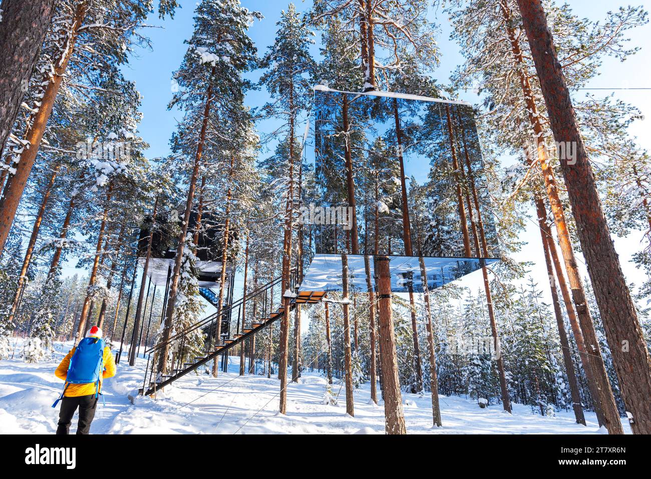 Vista di un turista ammirando la camera a forma di cubo con parete a specchio all'interno di una foresta boreale coperta di ghiaccio e neve, Tree hotel, Harads, Lapponia, Svezia Foto Stock