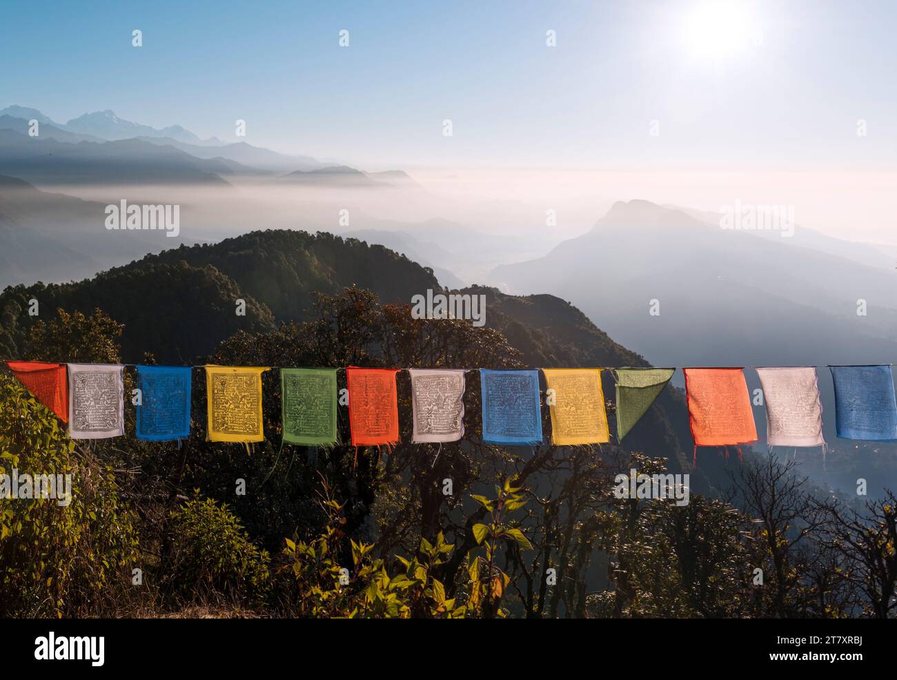Bandiere di preghiera colorate di fronte a un vasto paesaggio montano ai piedi del circuito dell'Annapurna nell'Himalaya, campo australiano, Nepal, Asia Foto Stock