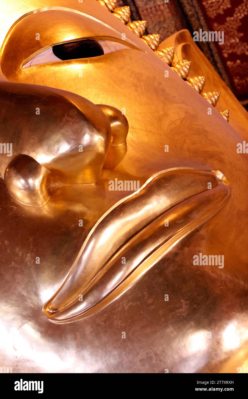 Wat Pho (Tempio del Buddha sdraiato), dettaglio del volto della grande statua dorata reclinata del Buddha (Phra Buddhasaiyas), Bangkok, Thailandia, Sud-Est asiatico Foto Stock