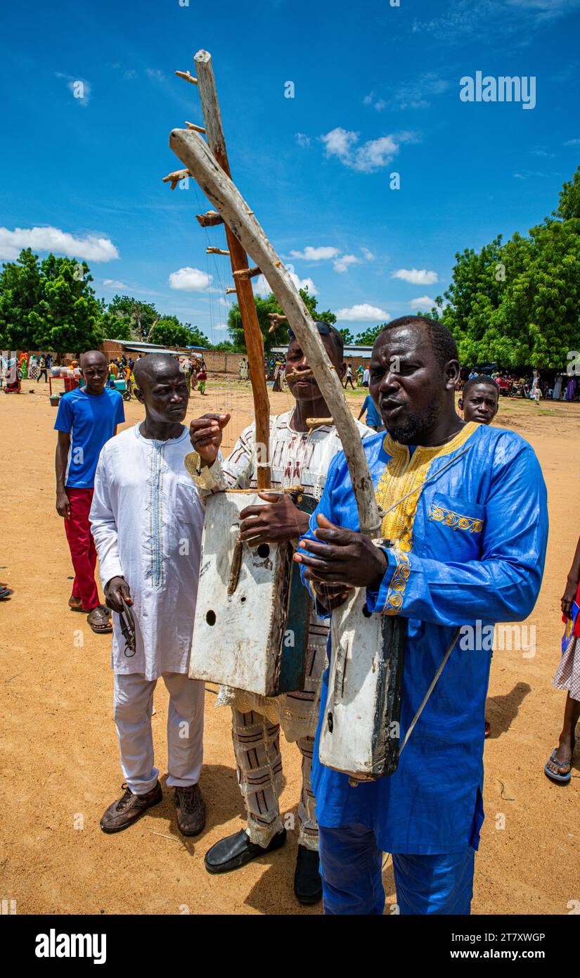 Uomo che suona uno strumento locale a un festival tribale, Ciad meridionale, Africa Foto Stock