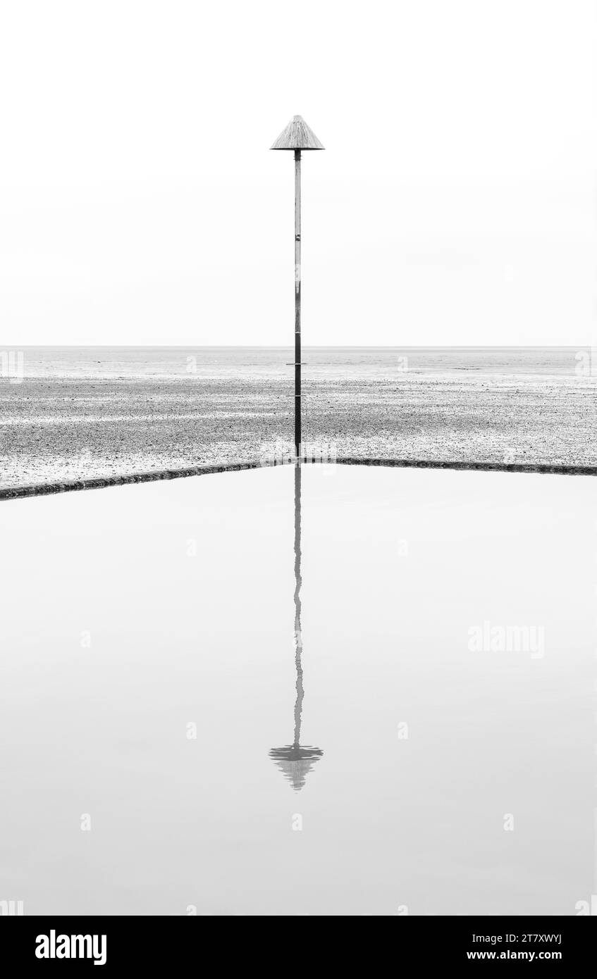 Un marcatore di groyne riflesso nel bacino di marea alla bassa marea, Leigh on Sea, Essex, Inghilterra, Regno Unito, Europa Foto Stock