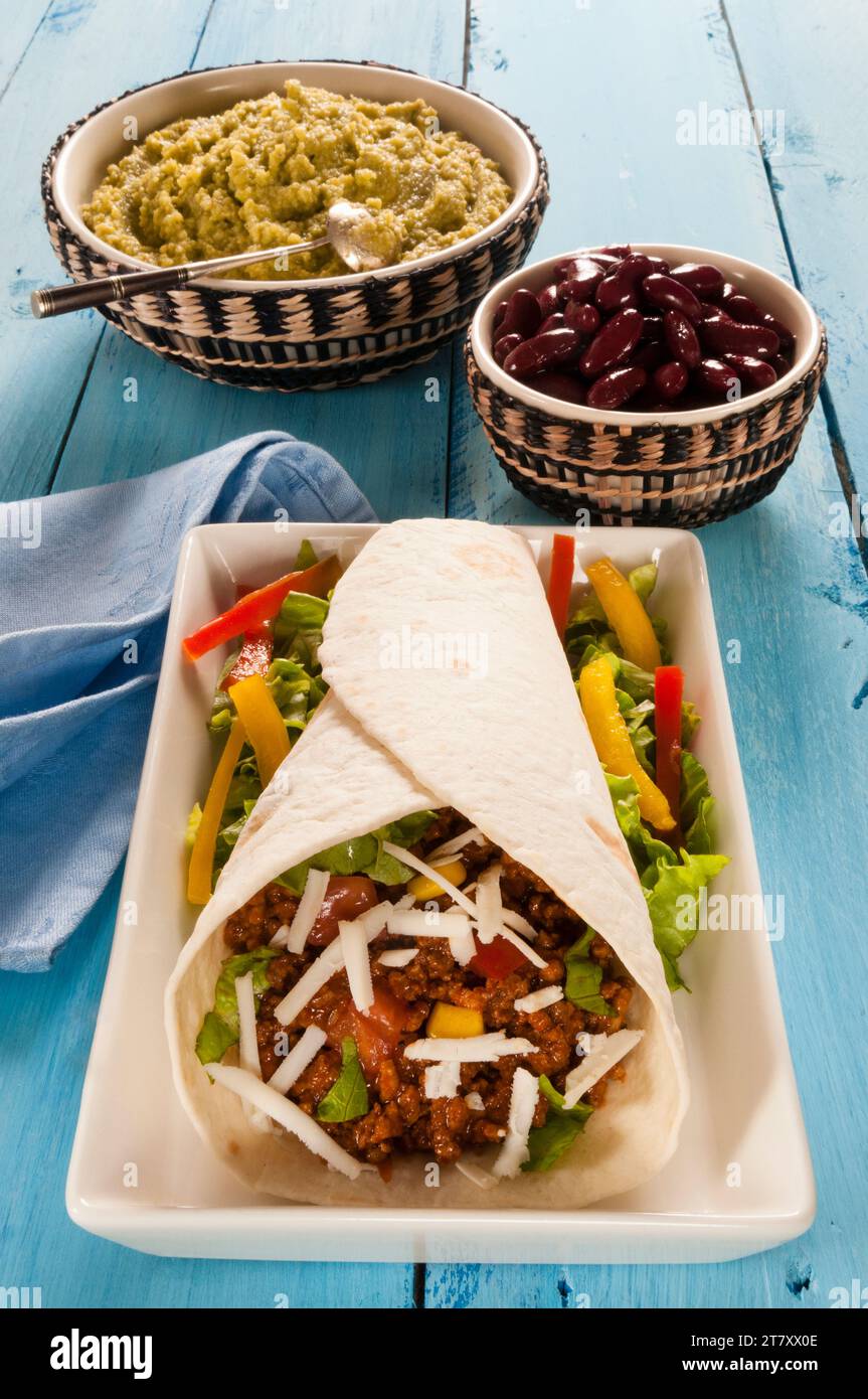 Taco di carne macinata in tortilla di farina con guacamole e fagioli, Messico, Nord America Foto Stock